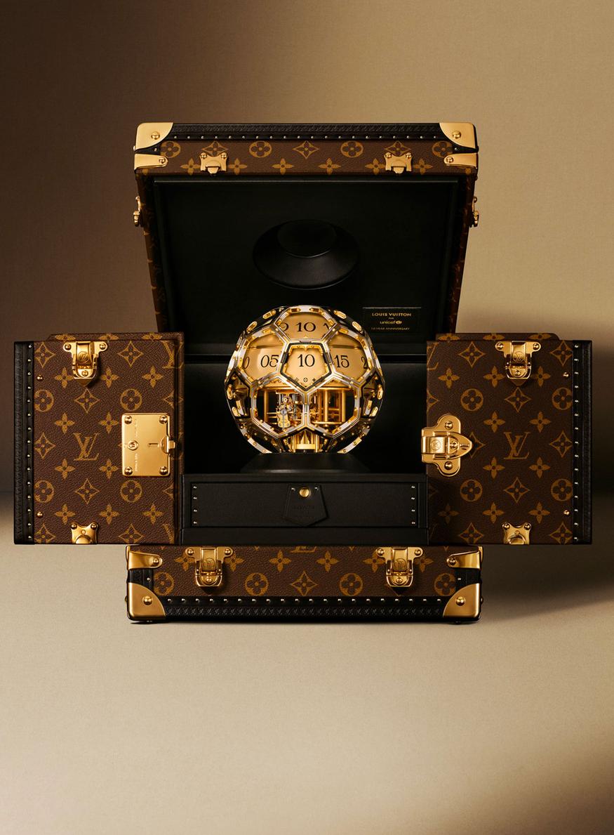 Horloge Louis Vuitton pour l'unicef en forme de ballon, conditionnée dans une malle monogrammée en cuir brun
